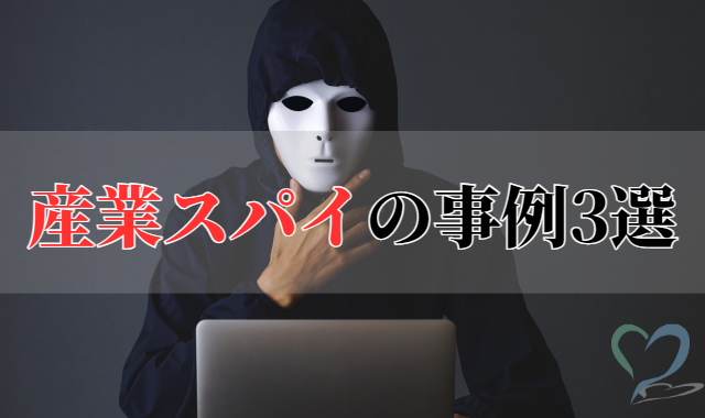 ノートパソコンを操作するフードを被ってお面をつけた男性